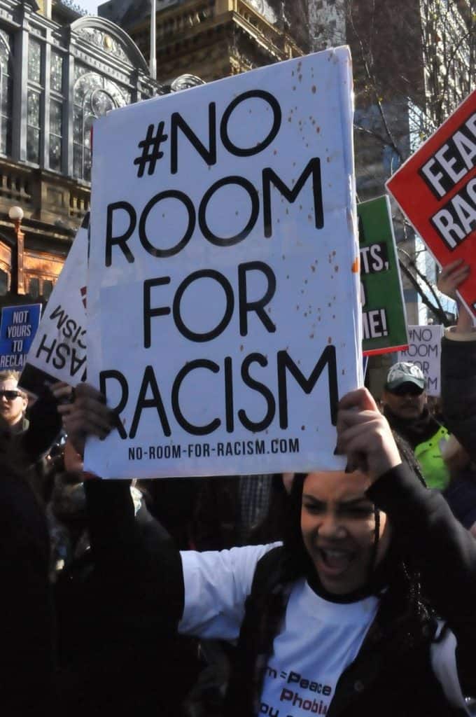 Protestor holding sign #No room for racism