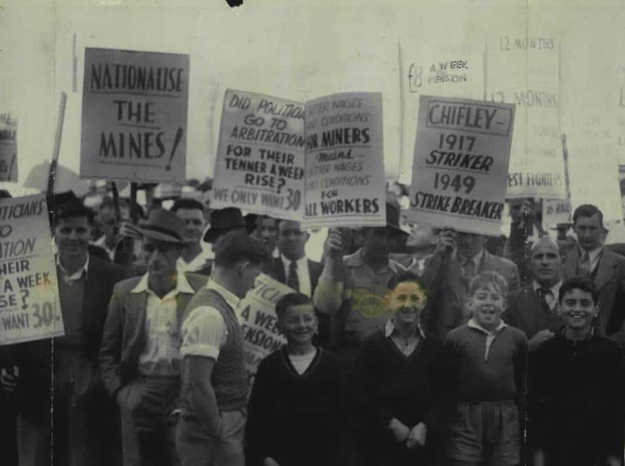 1949 coal strike: a group people stand together with placards reading 'Nationalise the Mines!' and 'Chifley: 1917 Striker, 1949 Strike Breaker'.