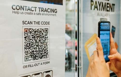 hand holding phone and scanning qr code for contact tracing