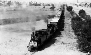 black and white photo of steam train pulling carriages