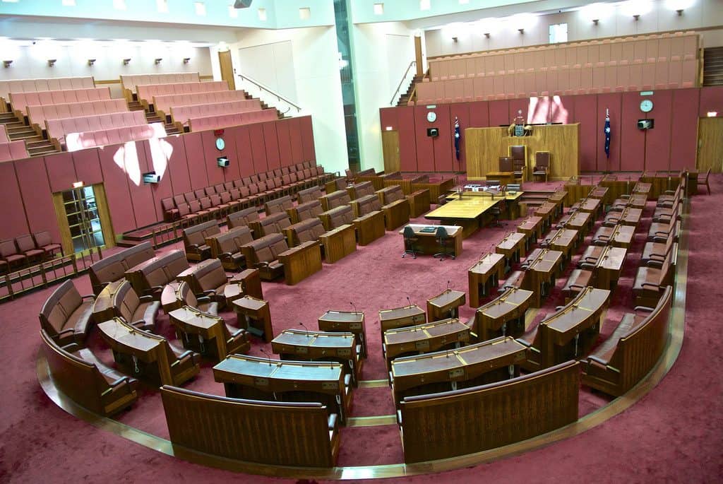 Photograph of the senate chamber showing maroon seats set up in a U shape.