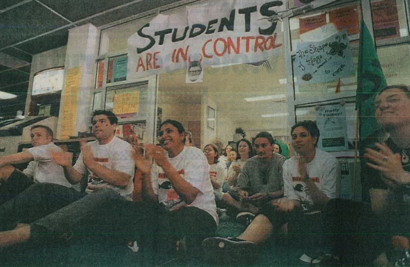 A group of students hold a meeting under a sign reading "Students are in control."|A group of students with one with a target on their head is accompanied with a caption reading Who's next? Are you in Prof. Barr's sights.|Students meet in an occupied space under a banner reading "Studnets are in control."|Sticker reading The Revolution Begins in Bankstown! The Power Where It Should Be. UWSM Student Occupation.
