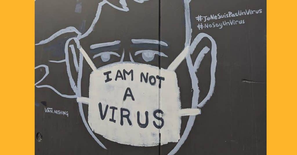 Photo of a mural which shows a person's face obscured by a protective mask with the writing 'I am not a virus'