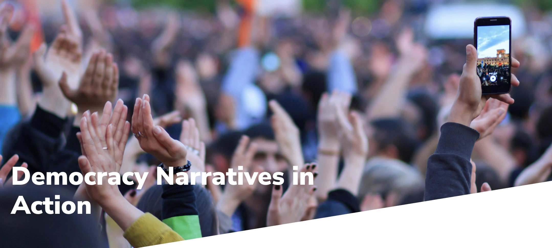 Title reads 'Democracy narratives in action'. Photo close up of a group of people with hands up in the air. One hand is holding a mobile phone and filming.|Title reads 'Pro democracy narrative playbook'. An arrow pointing up is next to the title. Paragraph text reads 'Building the capacity of movements to leverage the power of narratives