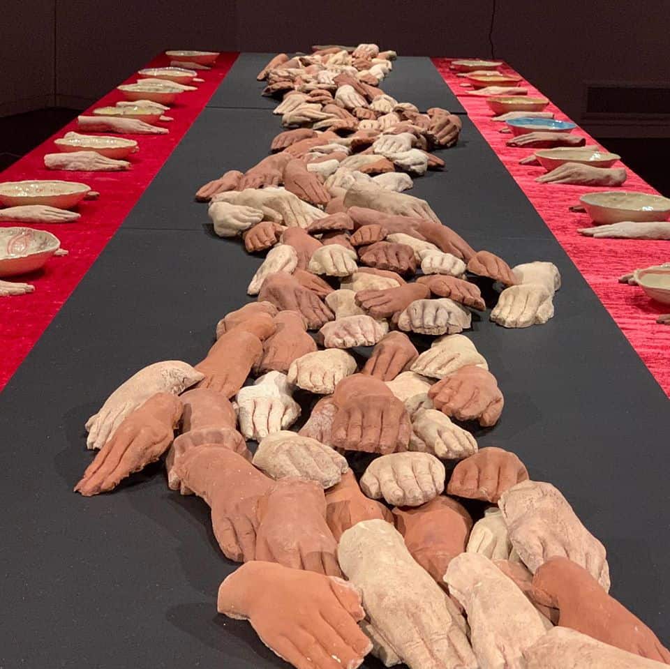 a row of ceramic hands on a table