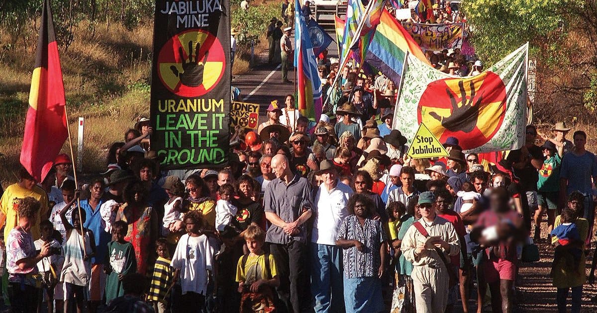 Photograph of protestors at the Jabiluka blockade in 1998. Features banners with 'Uranium