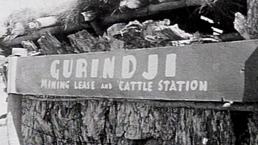 Black and white photograph of a sign that reads: 'GURINDJI Mining Lease and Cattle Station'.