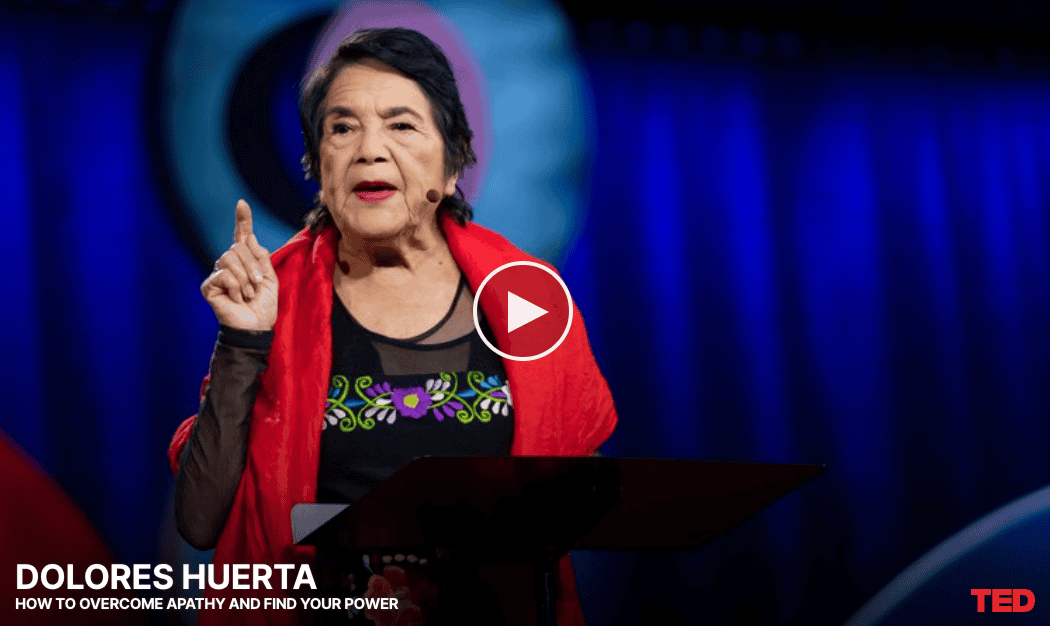 screenshot of video of a woman known as Dolores Huerta pointing her finger p as she gives a speech. Text reads 'Dolores Huerta; How to Overcome Apathy and Find your Power'.