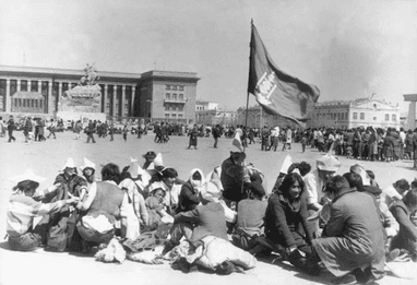 A group of people seated in a large square in Ulaanbatar