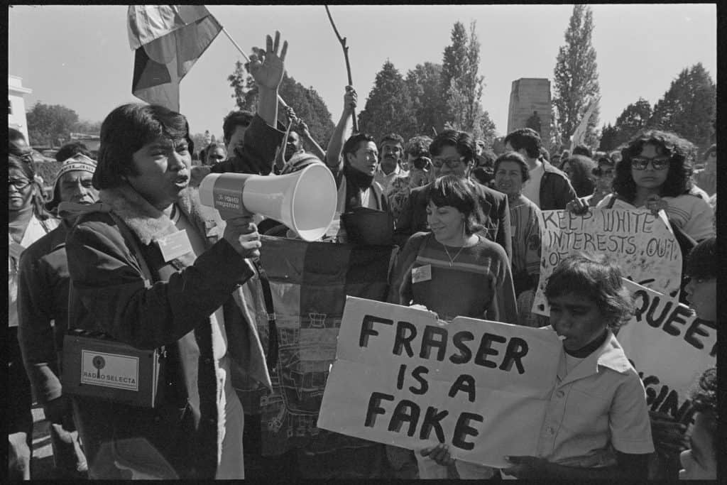 Demonstrators with loudspeaker and placards. One placard reads Fraser is a fake.