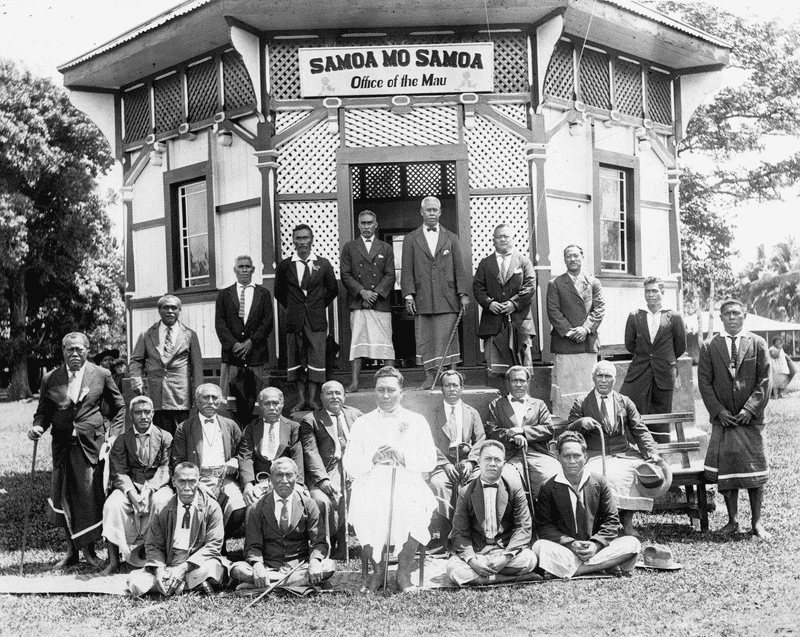 Black and white photograph of Mau leaders sitting in front of a building.