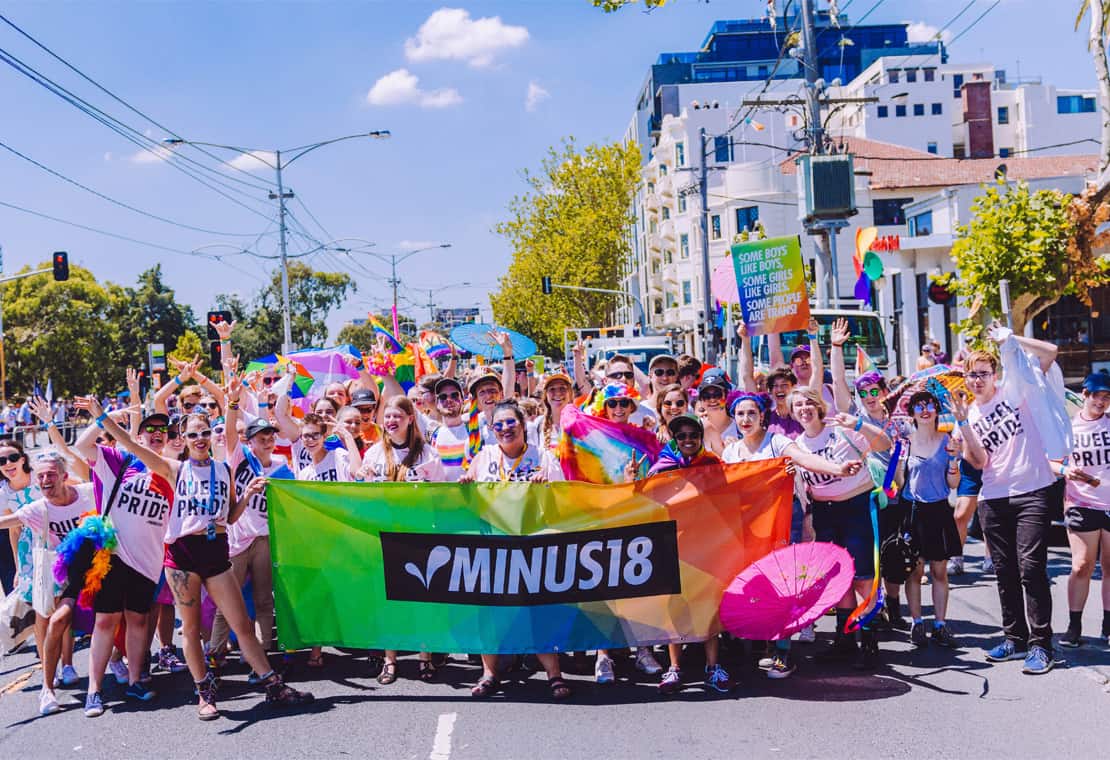 Photograph of a jubilant crowd of young people wearing 'Queer Pride' tshirts
