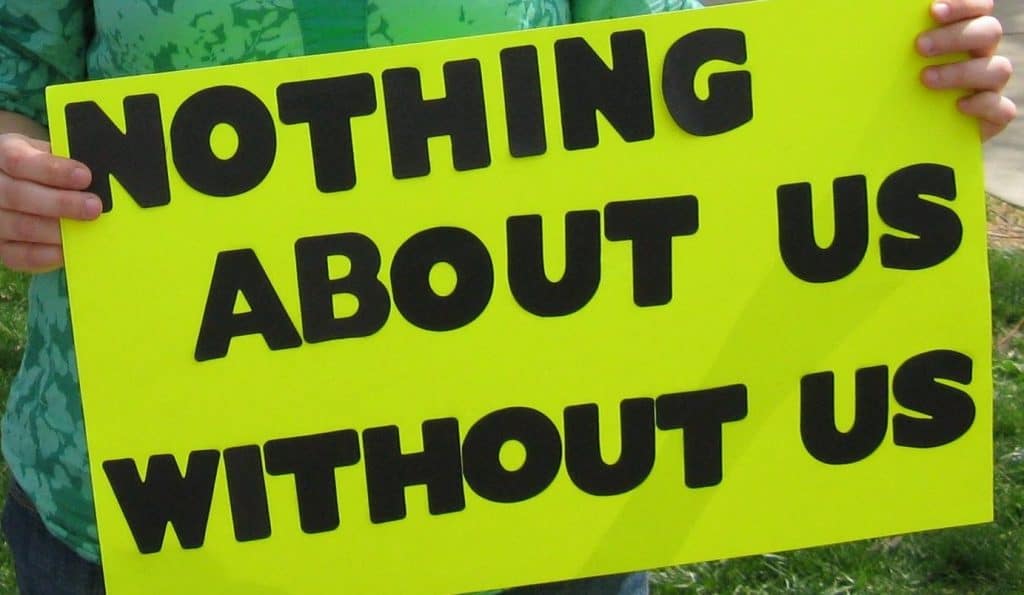 Close up of a placard: 'Nothing About Us Without Us'