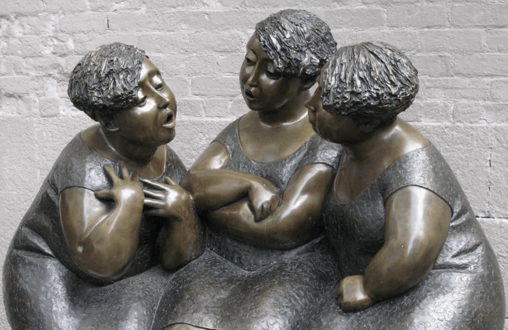 a statue of three women having a conversation