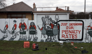 Art of Bunnings employees on garage door and fence with speech bubble saying "just dropping our penalty rates"