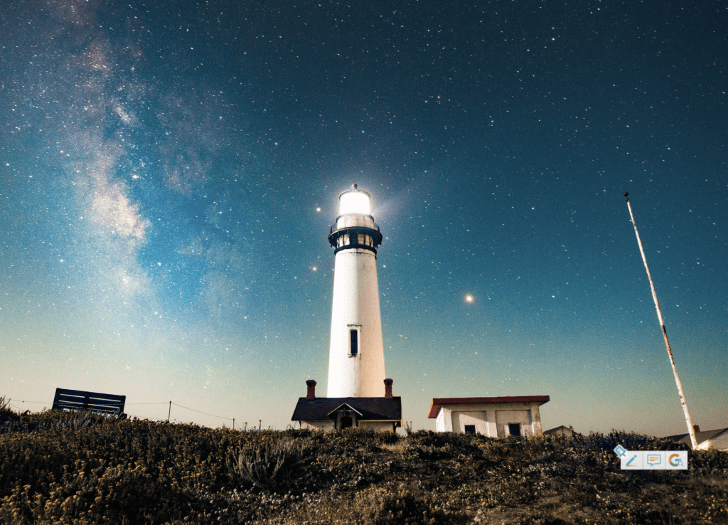 white lighthouse shining light at dusk