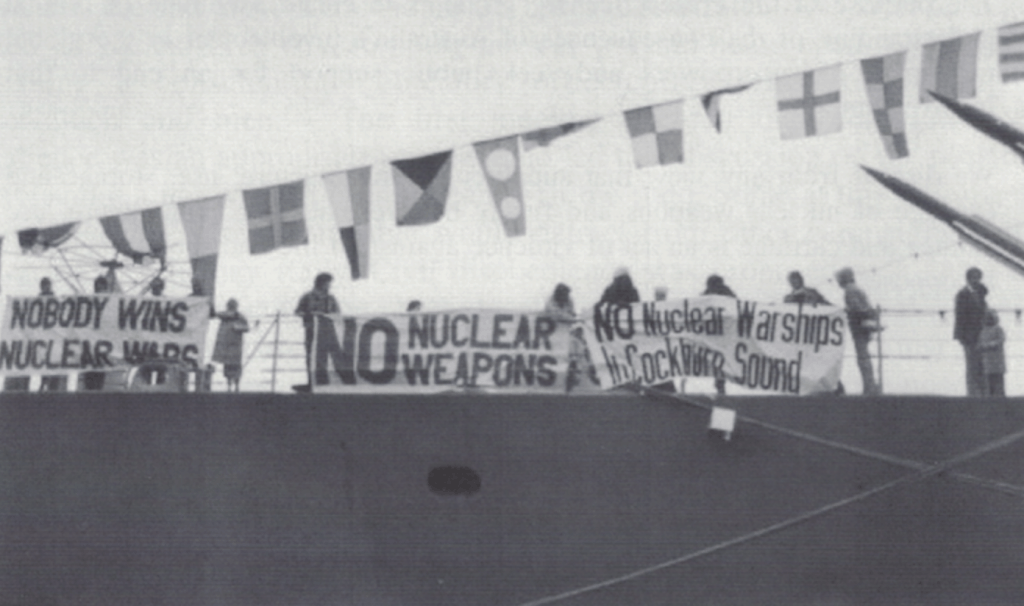 anti nuclear protestors on USS Worden ship with protest banners saying No Nuclear Weapons
