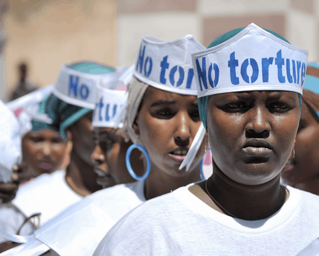 Singers wearing hats advocating “No Torture” line up before performing at a Human Rights Day event outside of Mogadishu Central Prison in Somalia.