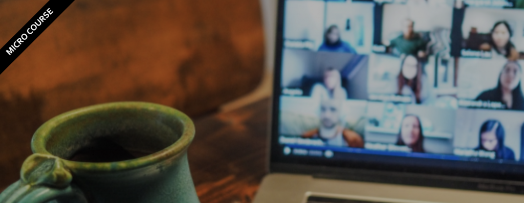 close up of green coffee cup in front of laptop screen showing multiple faces on screen having an online meeting