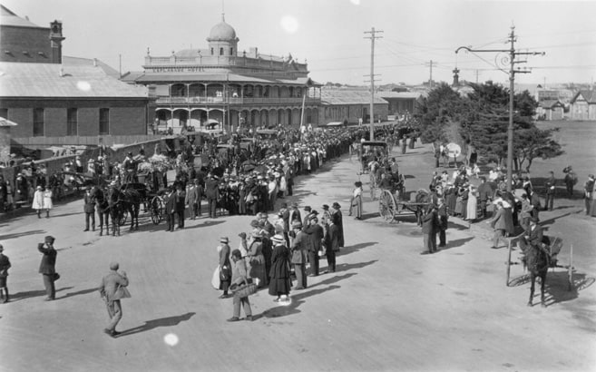 Black and white photo of hundreds of people walking down the street as part of funeral procession in Fremantle