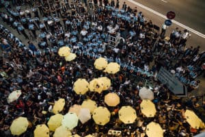 Pro-democracy protesters hold umbrellas in front of police cordon line outside of the Hong Kong Government Complex.