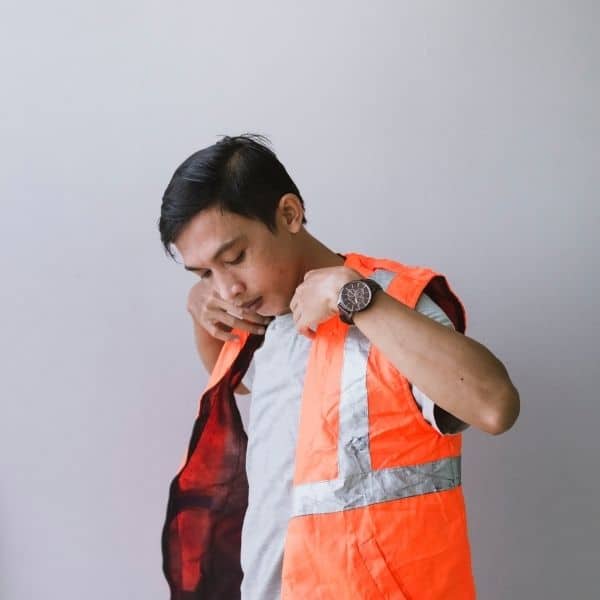Young man putting on hi visibility vest