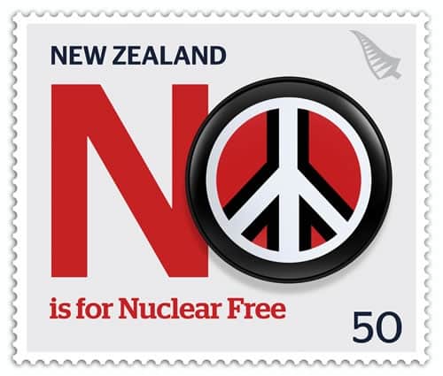 a stamp with text New Zealand NO is for Nuclear Free. The No is emphasized and the the O has a peace symbol inside the letter. There is a silver fern in the top right hand corner